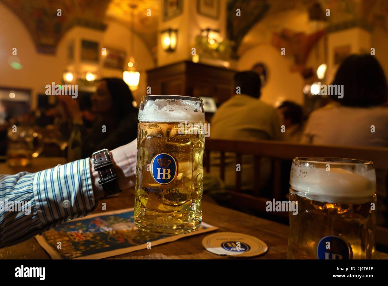 Monaco di Baviera, Germania - 04.07.2022: Famoso hofbrauhaus tradizionale pud keller a Monaco di Baviera uomo che tiene HB birra brocca Krugel Foto Stock