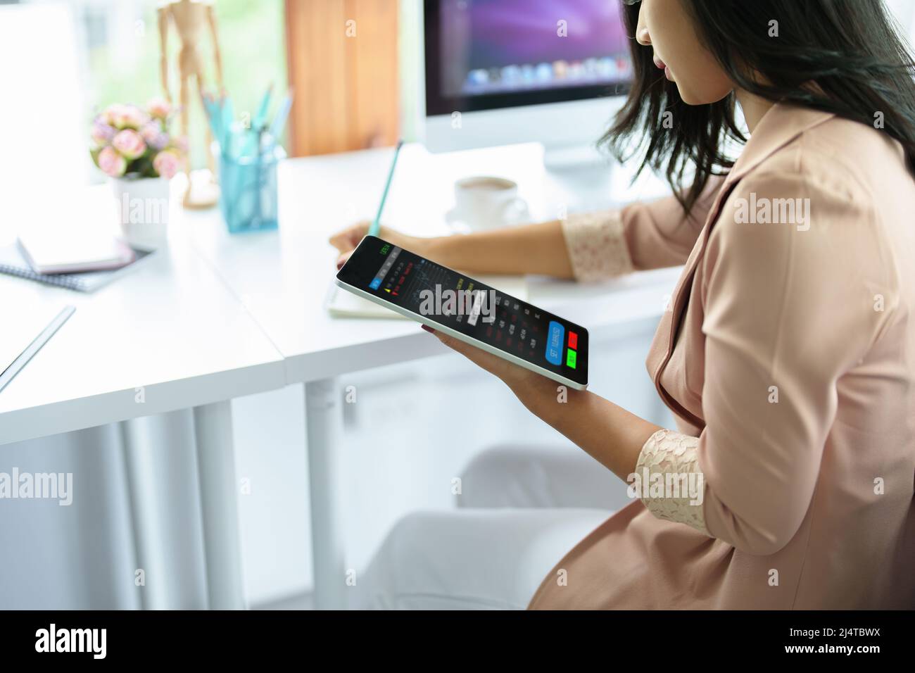 Concetto di pianificazione finanziaria e di investimento, donna d'affari femminile che utilizza il computer per analizzare i grafici per trovare punti di ingresso su un bordo di negoziazione. Attraverso Foto Stock