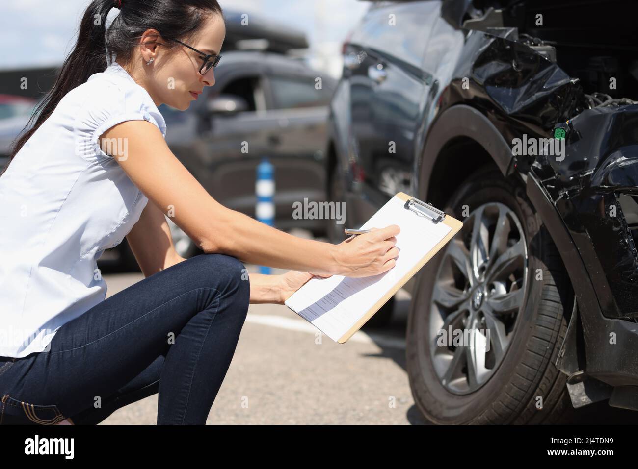 L'agente assicurativo registra i danni all'auto dopo l'incidente Foto Stock