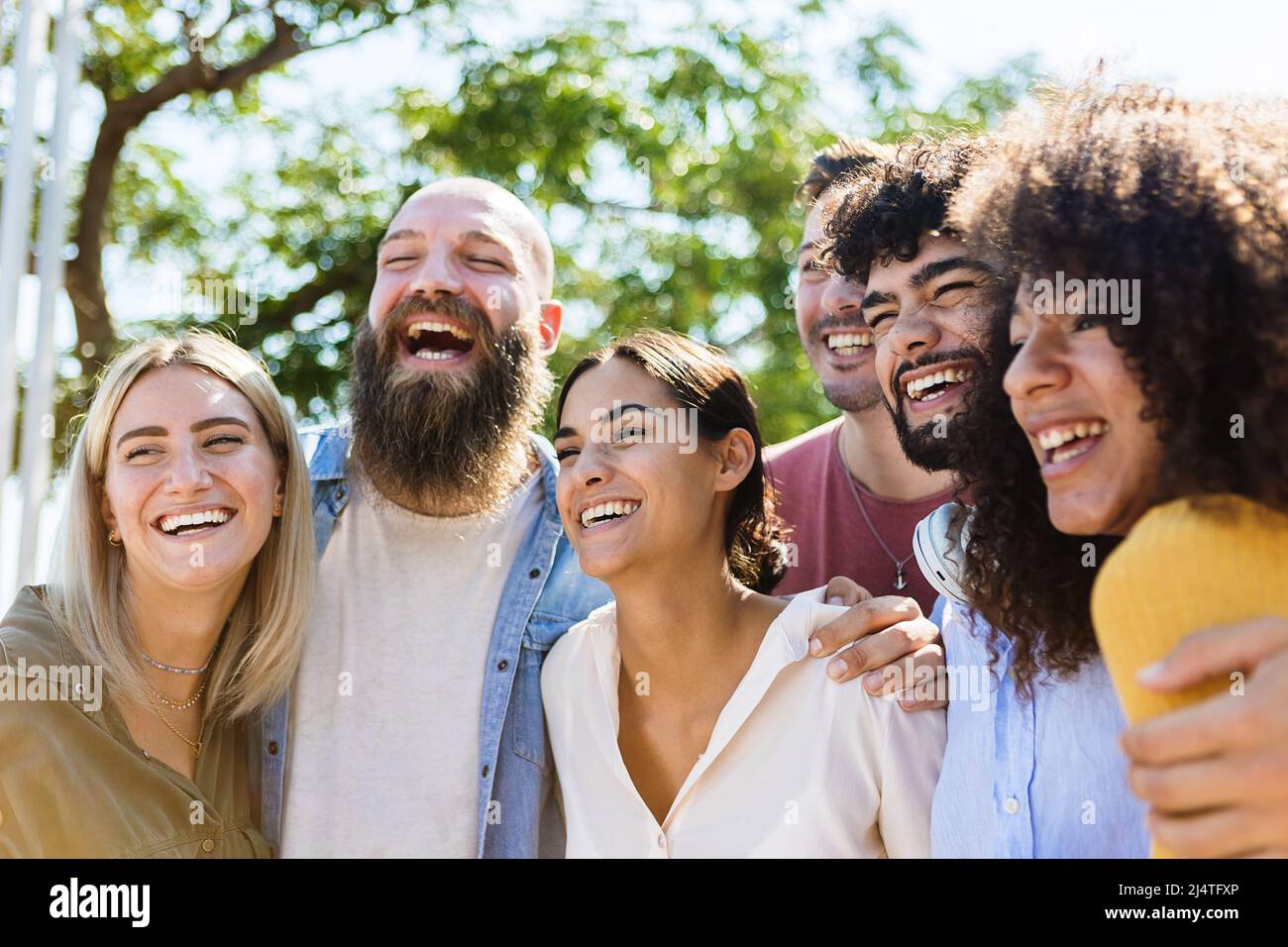 Giovane gruppo di amici diversi che si divertono all'aperto in una giornata di sole Foto Stock