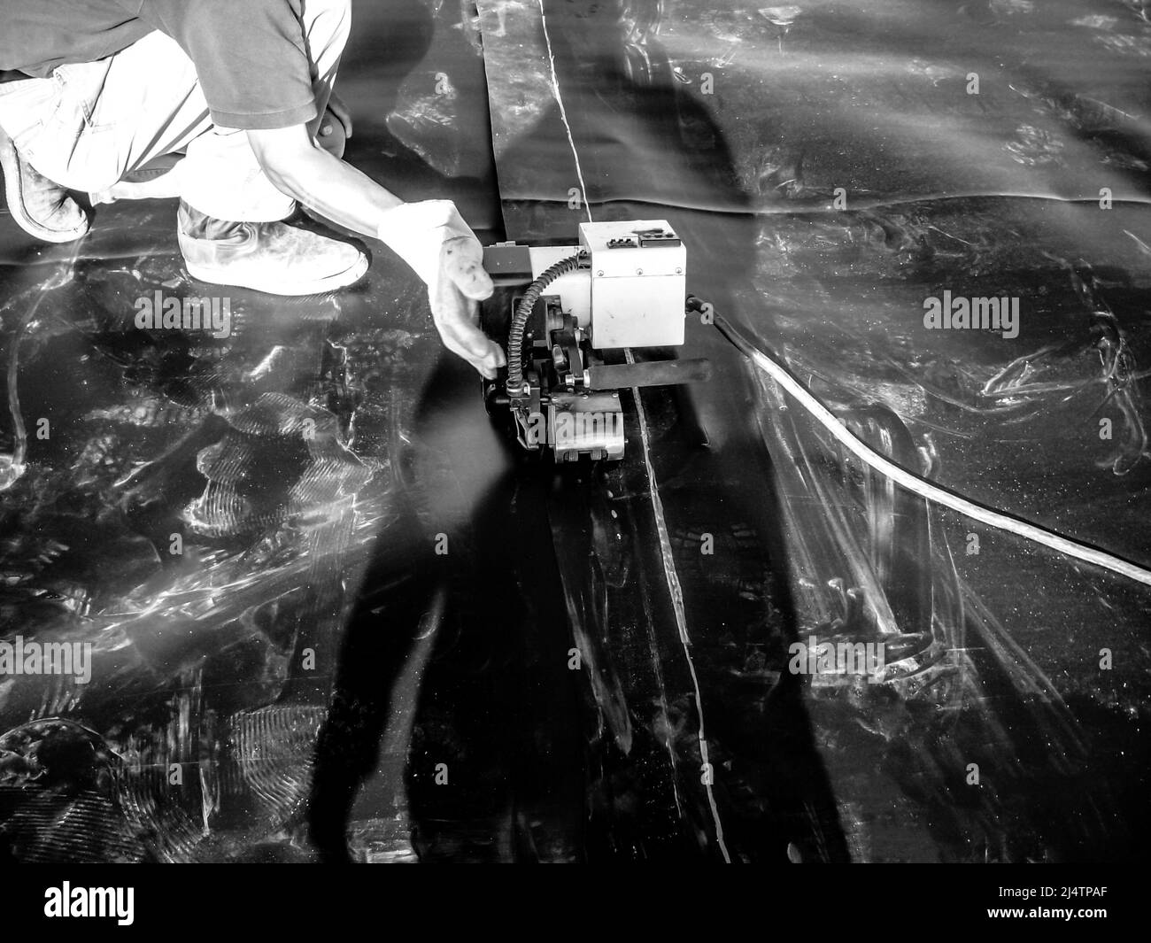 Giunzione tra due fogli di rivestimento in HDPE saldati a caldo insieme in un progetto di espansione di discarica. Foto Stock