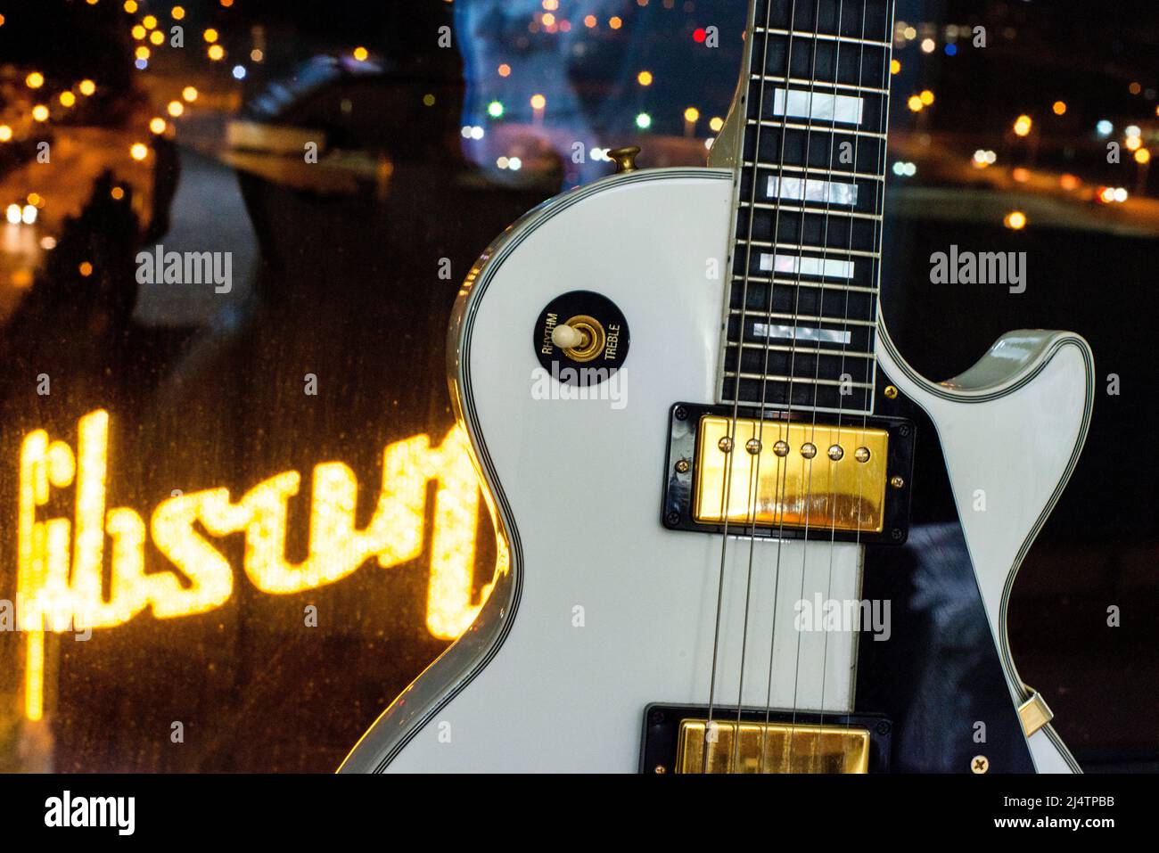 Chitarra bianca Gibson di fronte alle luci della città e alle luci della  fabbrica della chitarra Gibson Foto stock - Alamy