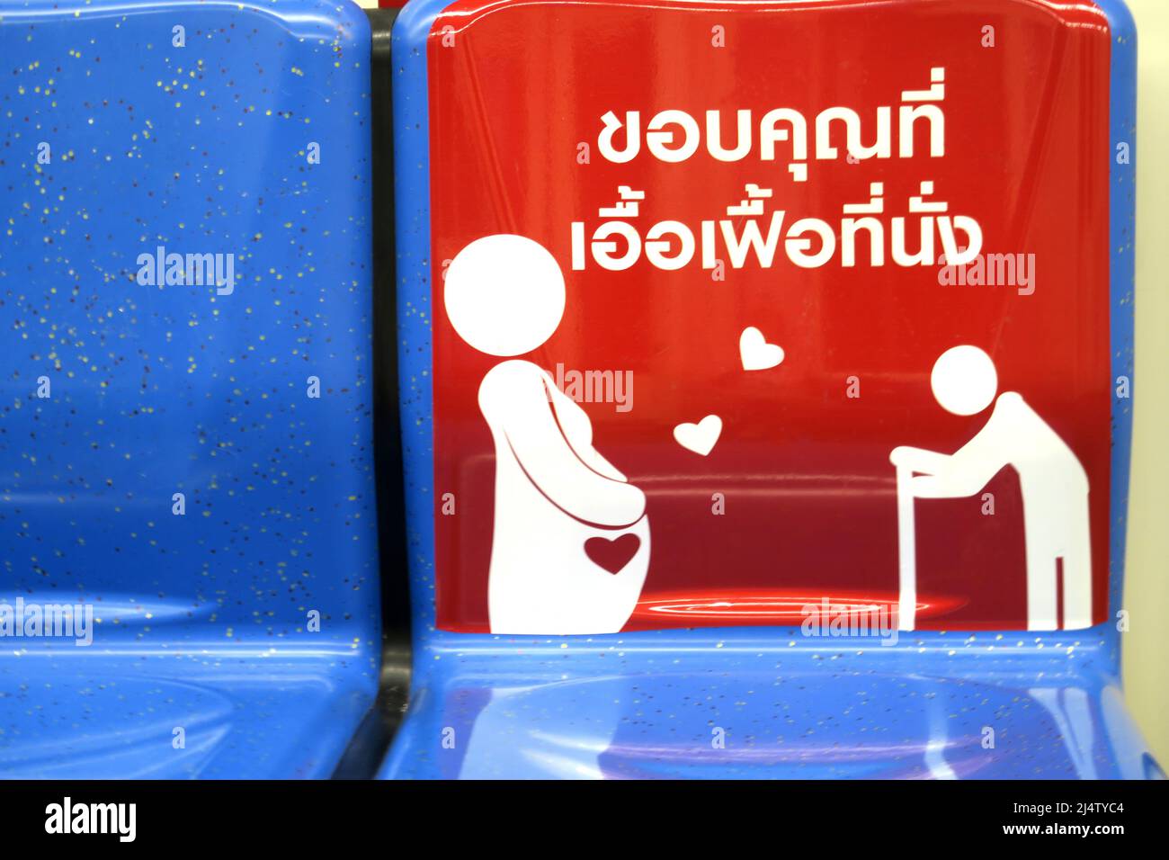 Posti a sedere sul Bangkok BTS Skytrain suggerendo di prendere posto per i meno abili, con donne incinte e gli anziani suggeriti Foto Stock