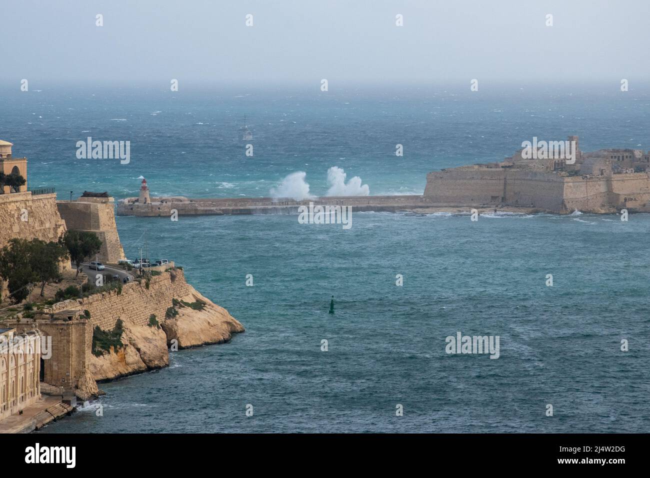 L'acqua si surge sul Forte Ricasoli Breakwater che custodisce l'ingresso al Grand Harbour a la Valletta, Malta. Foto Stock