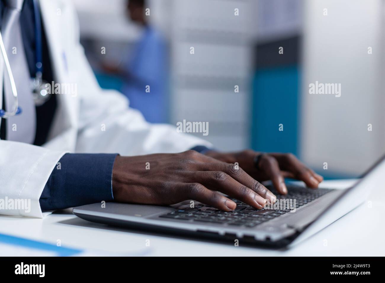 Primo piano di uno specialista clinico che utilizza un computer portatile per analizzare le condizioni del paziente e il programma di trattamento. Medico sanitario che controlla il database dei medicinali prescritti durante la segnalazione della diagnostica. Foto Stock