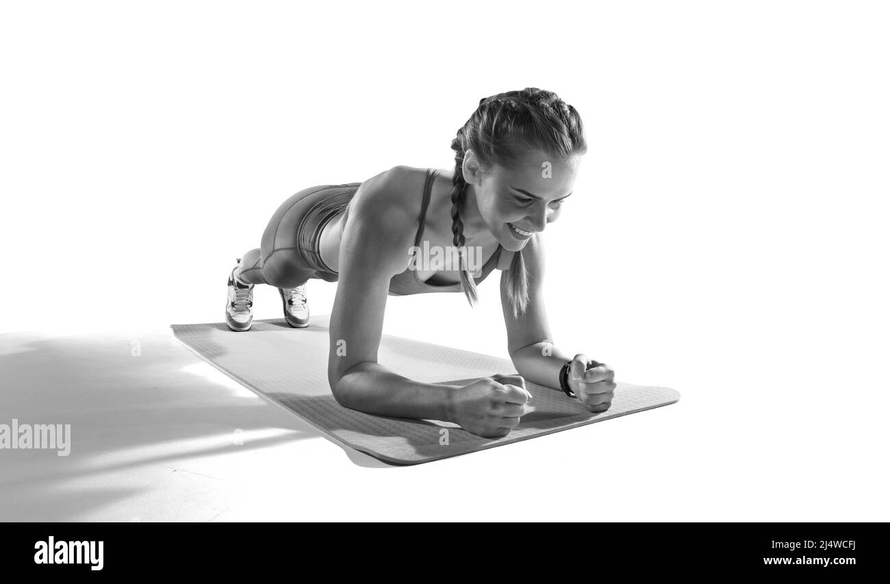 Sport. Donna muscolare su una posizione asse utilizzare gomma fitness. Muscolare e forte ragazza esercizio. Foto Stock