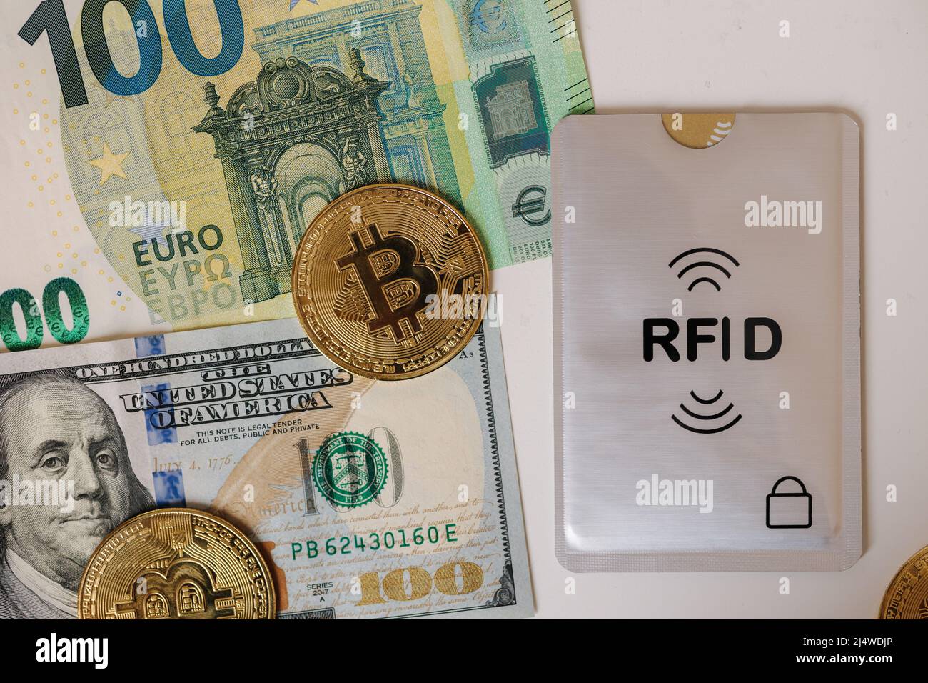 Bitcoin dollari USA, euro e carta di credito con custodia RFID protettiva. Carte di pagamento contactless NFC. Cyber-cryme Foto Stock