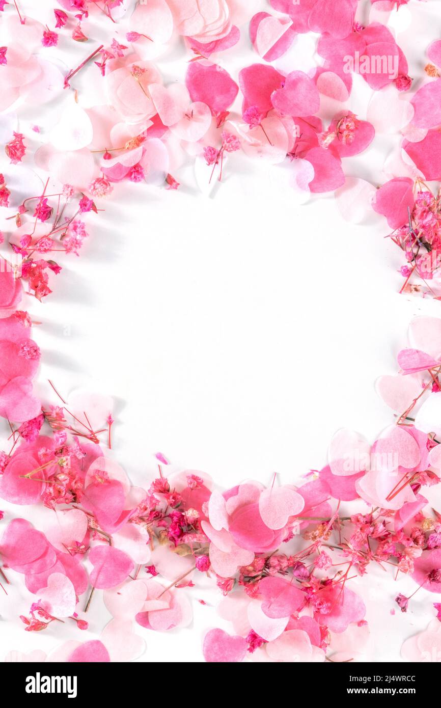 Biglietto di auguri di San Valentino o sfondo di invito al matrimonio con cuori di carta rosa e fiori di rosa confetti, un modello di design su sfondo bianco Foto Stock