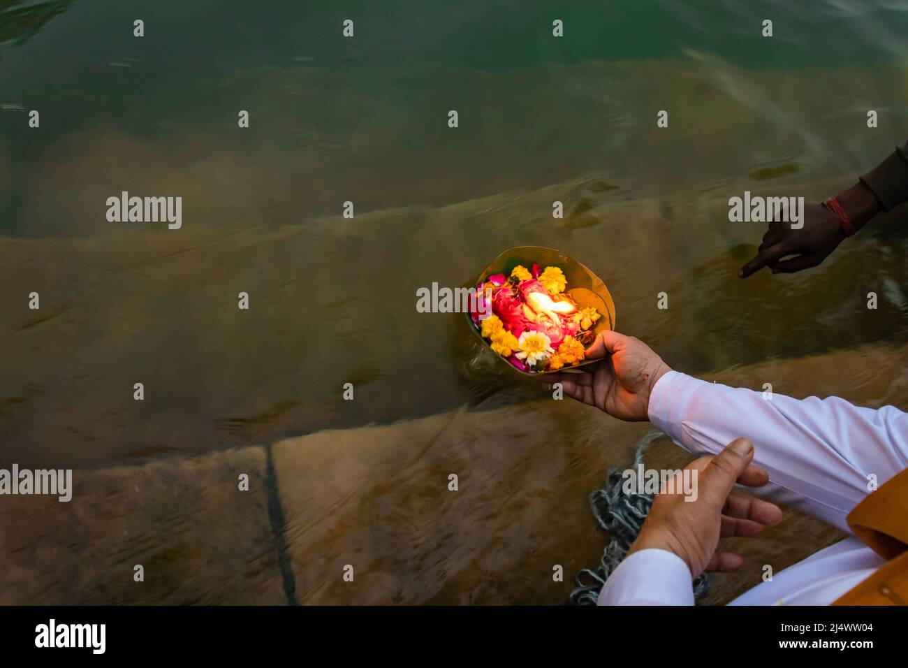 il devotee offre fiori al fiume santo al mattino dall'angolo superiore Foto Stock