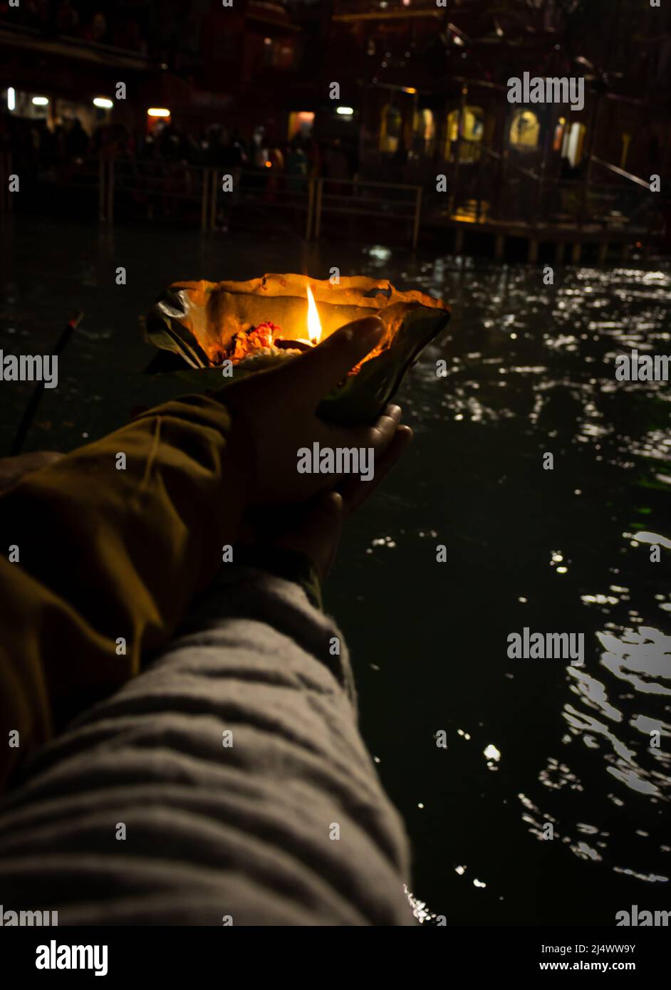devotee che tiene aarti flower pot per ganges fiume preghiera serale di notte Foto Stock