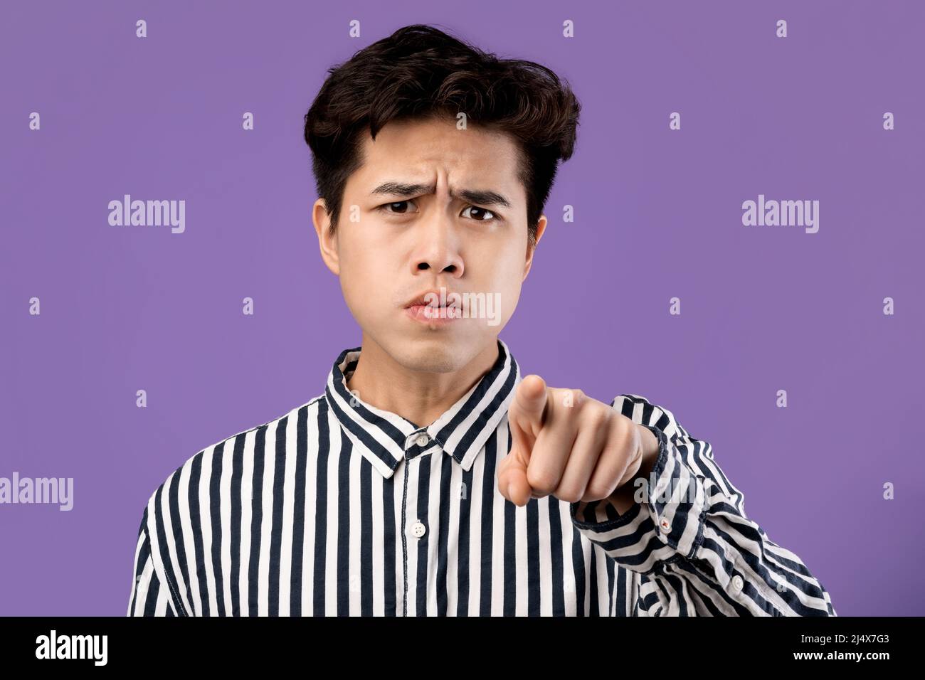 Ritratto di uomo asiatico arrabbiato puntando il dito alla fotocamera Foto Stock