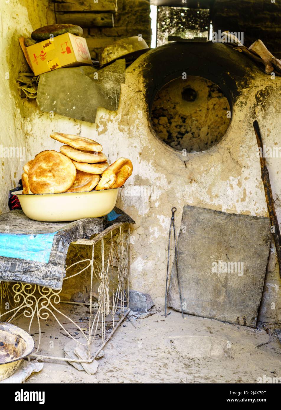 Pane tagico tradizionale non o naan appena sfornato in una cucina primitiva in un villaggio remoto in Tagikistan Foto Stock