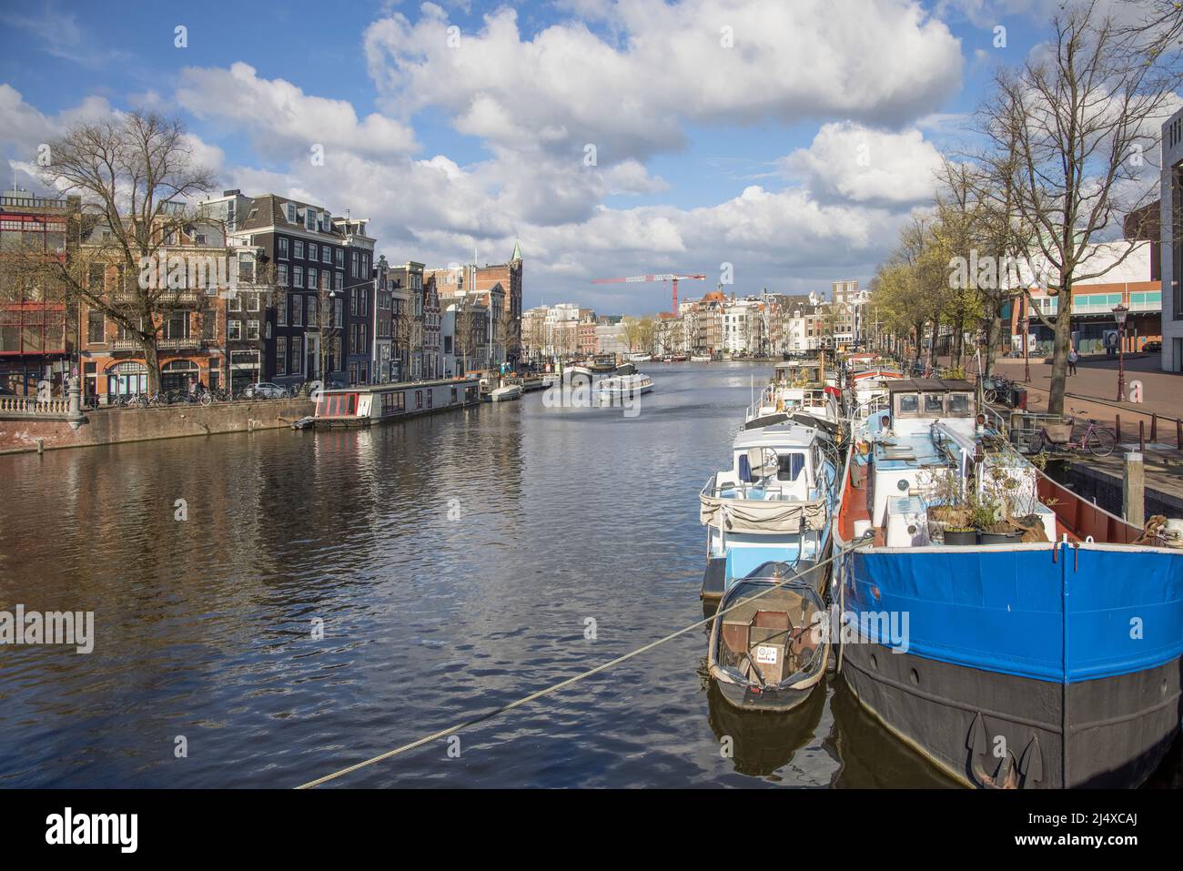 case galleggianti e chiatte ormeggiate lungo uno dei molti canali e corsi d'acqua di amsterdam olanda Foto Stock