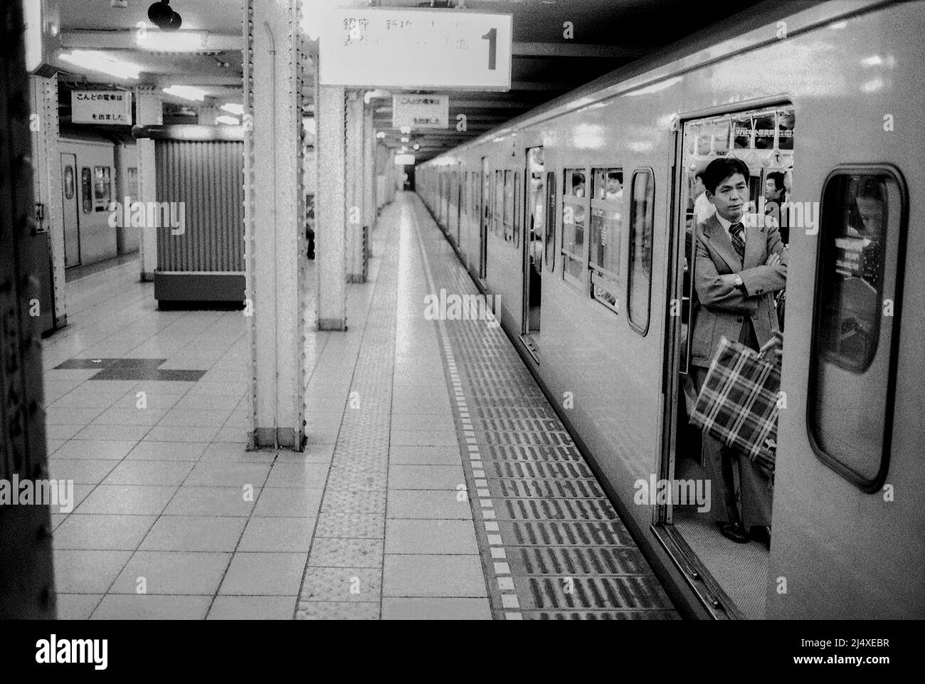 TRENO DELLA METROPOLITANA DI TOKYO alla stazione con passeggeri Foto Stock