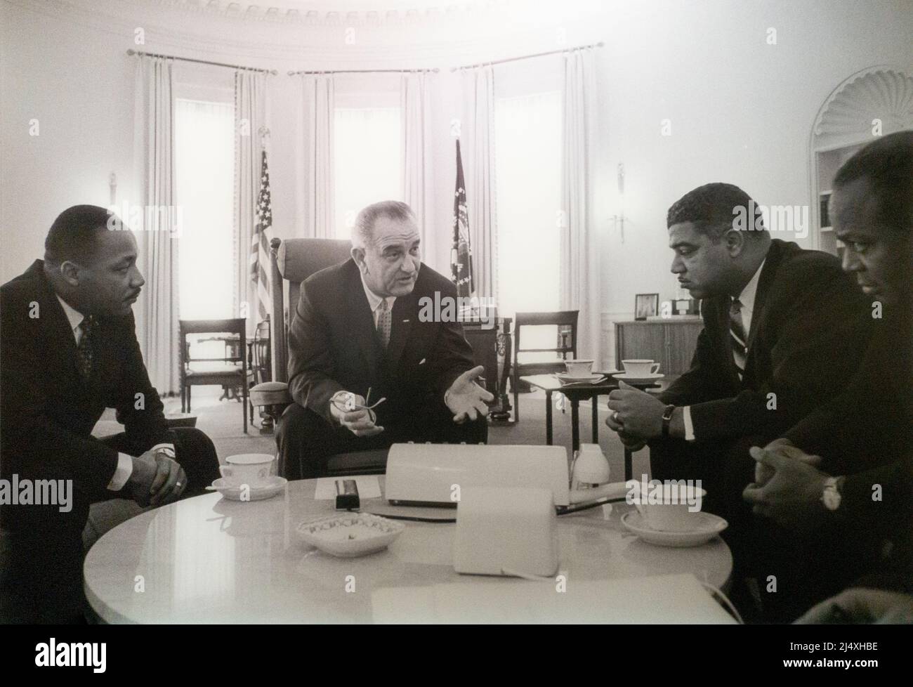 Il presidente degli Stati Uniti Lyndon Baines Johnson LBJ parla di leader neri per i diritti civili nell'ufficio ovale preso il 18 gennaio 1964 da Yoichi Okamoto, il presidente Lyndon B. Johnson incontra un gruppo di leader per i diritti civili. Tra i gruppi vi sono il Rev. Dr. Martin Luther King, Jr. Della Southern Christian Leadership Conference (sinistra), Whitney M. Young, Jr. Della National Urban League (destra), e James Farmer del Congresso dell'uguaglianza razziale (estrema destra). Foto Stock