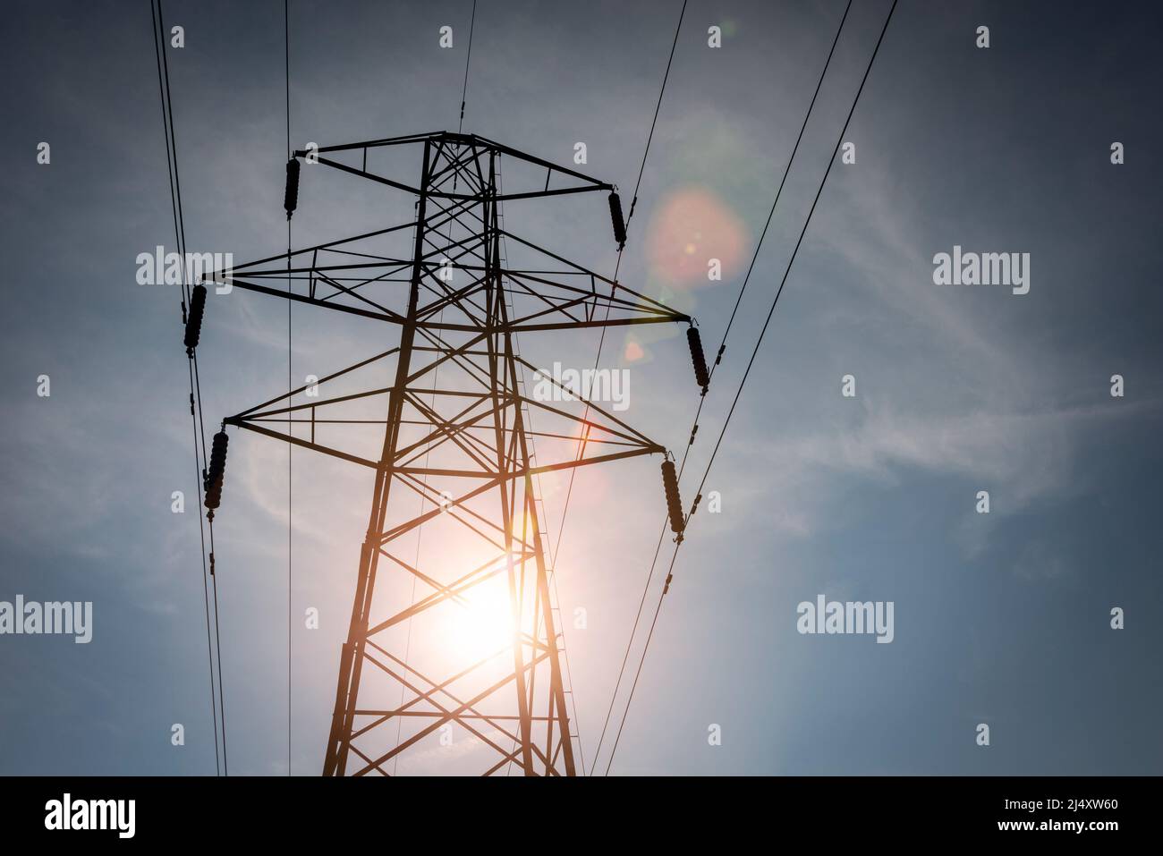 Tralicci di elettricità e cavi di alimentazione con luce solare. Foto Stock