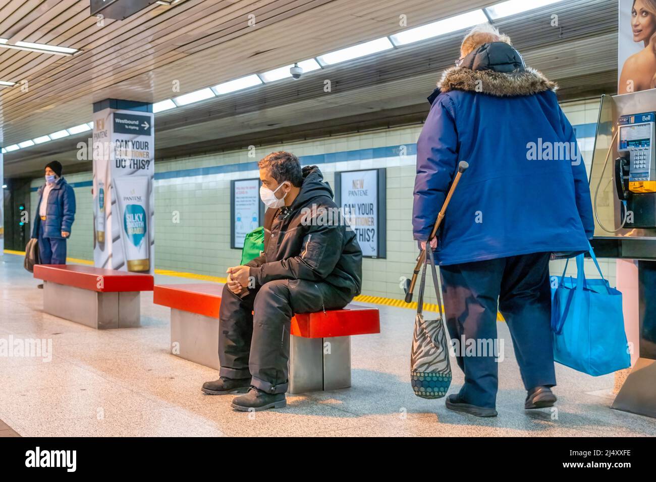 Persone che indossano maschere in una piattaforma di una stazione della metropolitana TTC. La Toronto Transit Commission è il più grande sistema di trasporto pubblico del Canada. Foto Stock