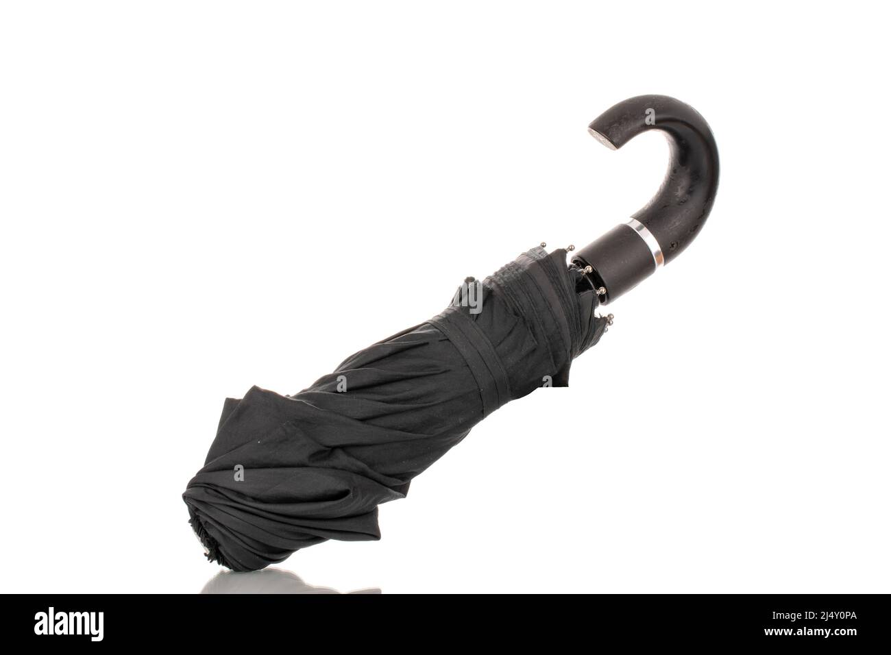 Un ombrello nero ripiegato, macro, isolato su sfondo bianco. Foto Stock