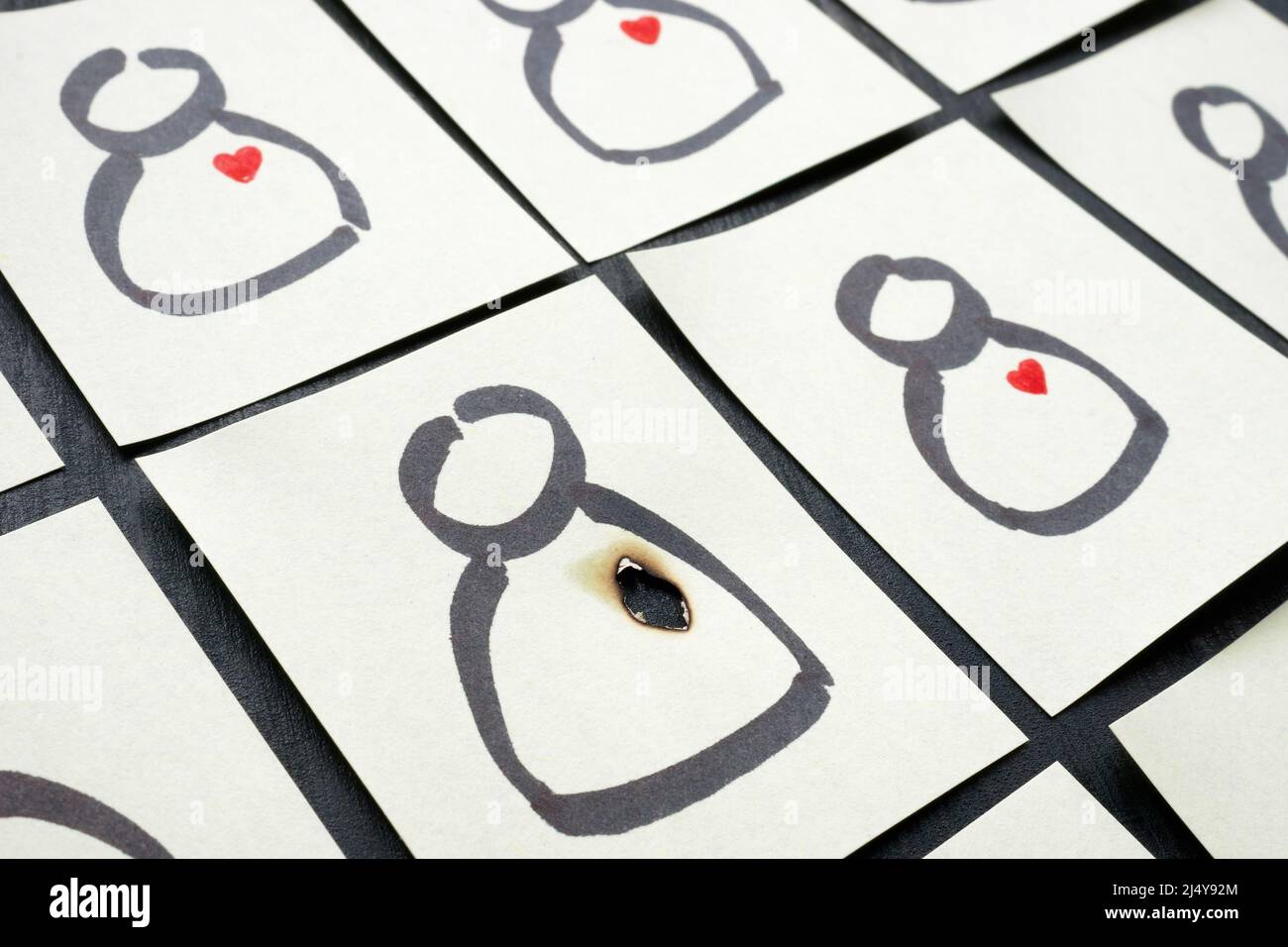 Una figurina con un cuore bruciato. Problemi di relazione, desiderio. Foto Stock