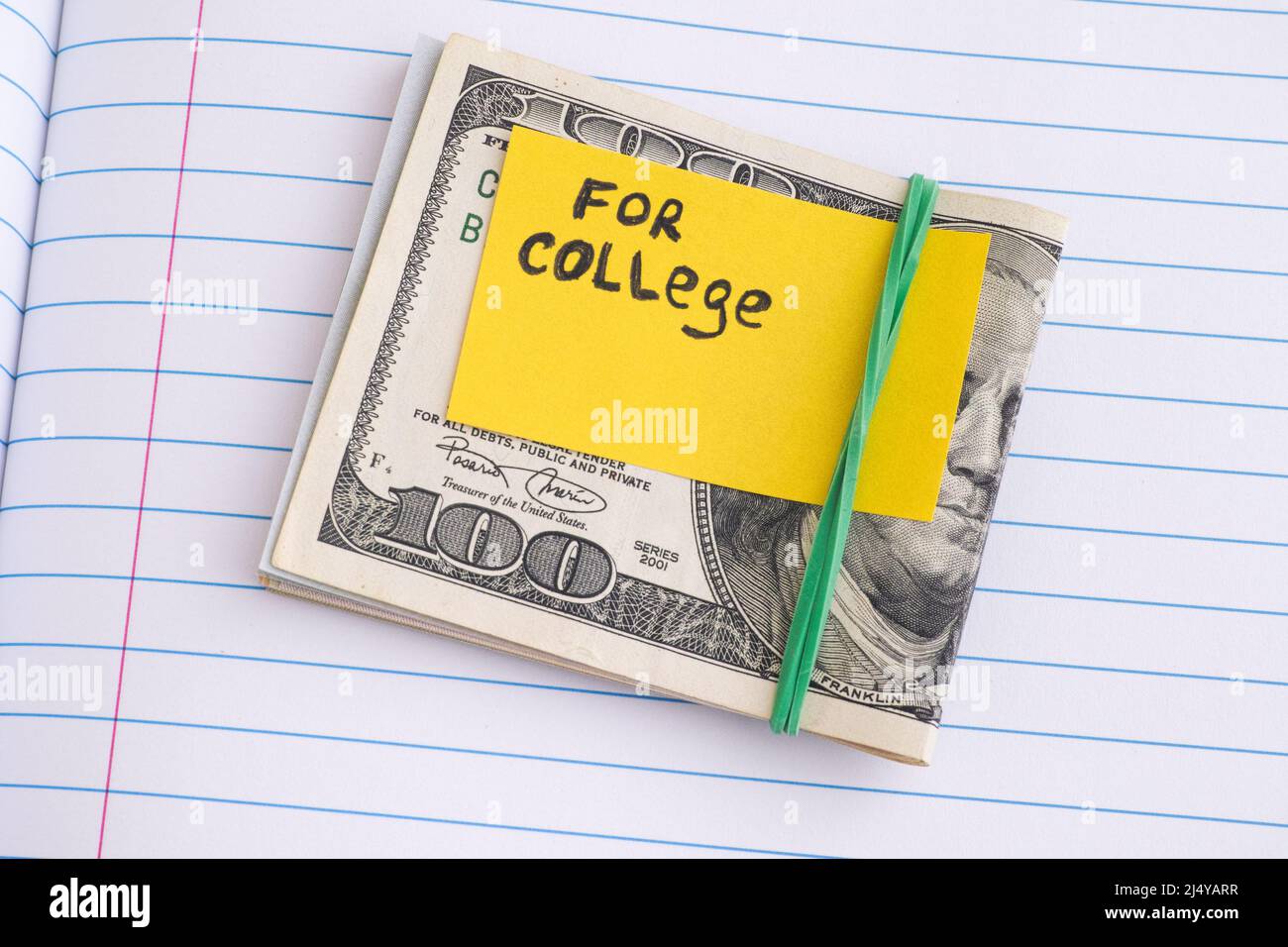 Circa cento fatture del dollaro con una nota gialla della carta che dice per l'università su esso con una fascia di gomma intorno loro. Primo piano. Foto Stock