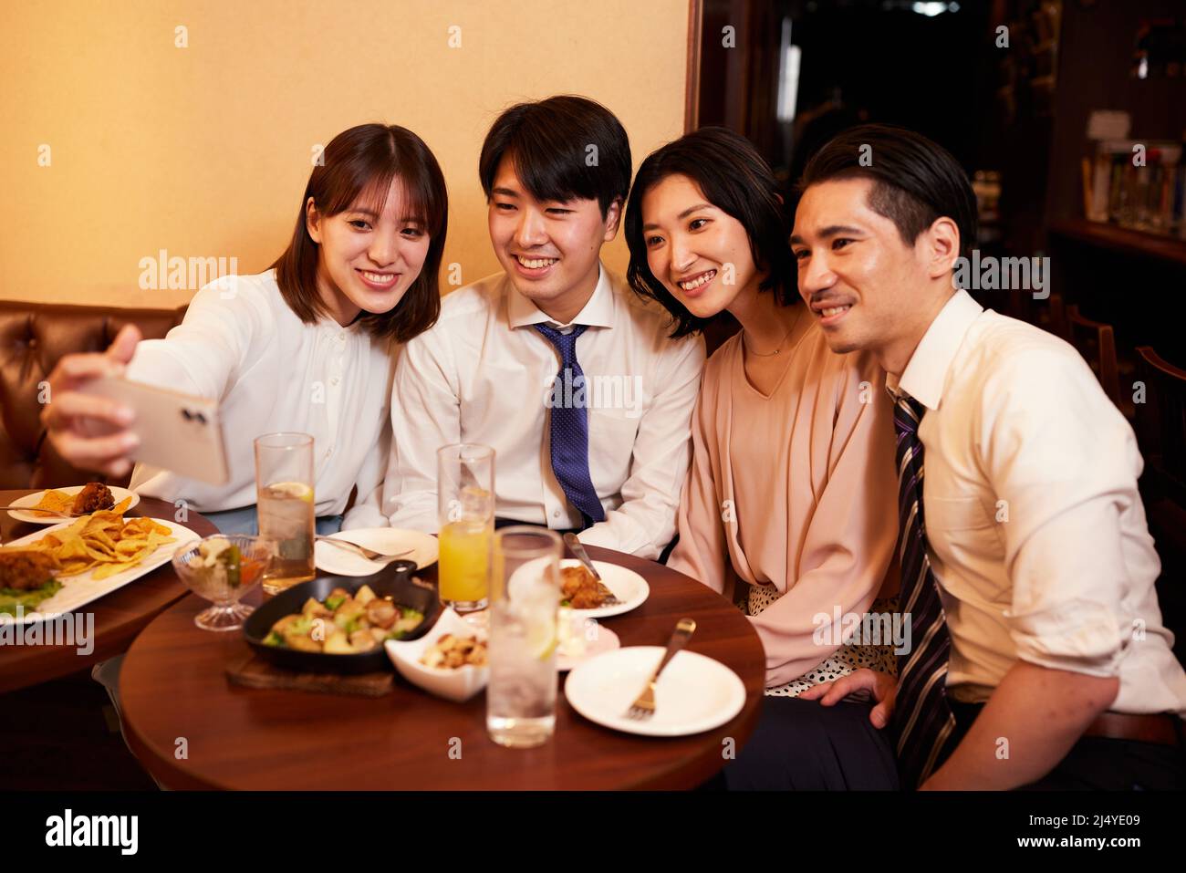 Gli uomini d'affari giapponesi hanno bevute e cenano in un bar Foto Stock