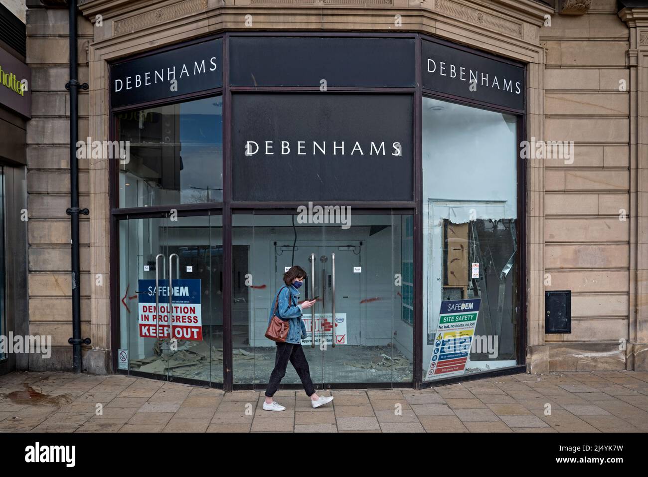 Yound donna che indossa una maschera passeggiate vicino al negozio Debenhams chiuso in Princes Street, Edimburgo, Scozia, Regno Unito. Foto Stock