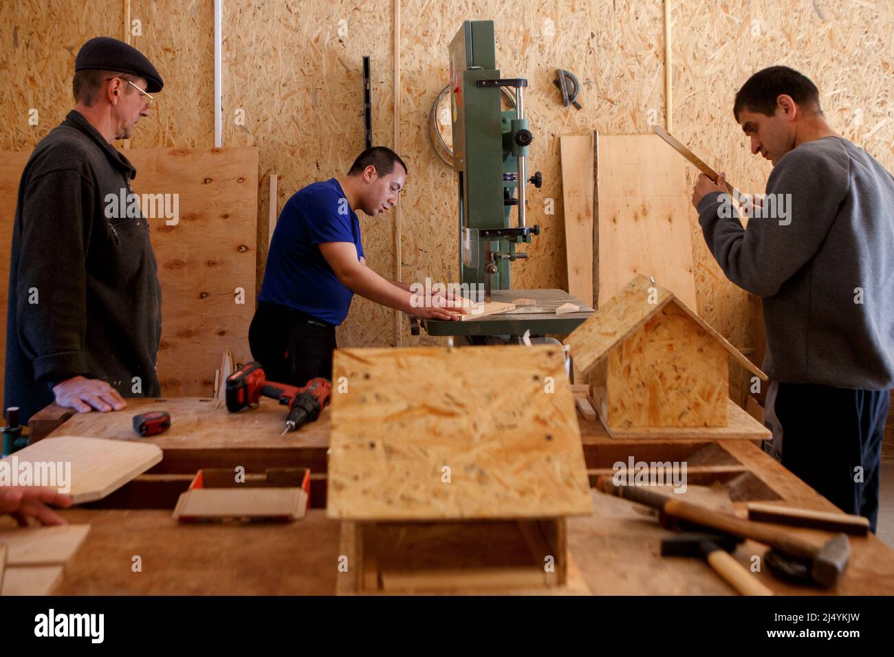 VILSHANY, UCRAINA - 15 APRILE 2022 - gli uomini sono visti in un laboratorio di lavorazione del legno in una pensione locale per bambini disabili e mentalmente sfidati Foto Stock