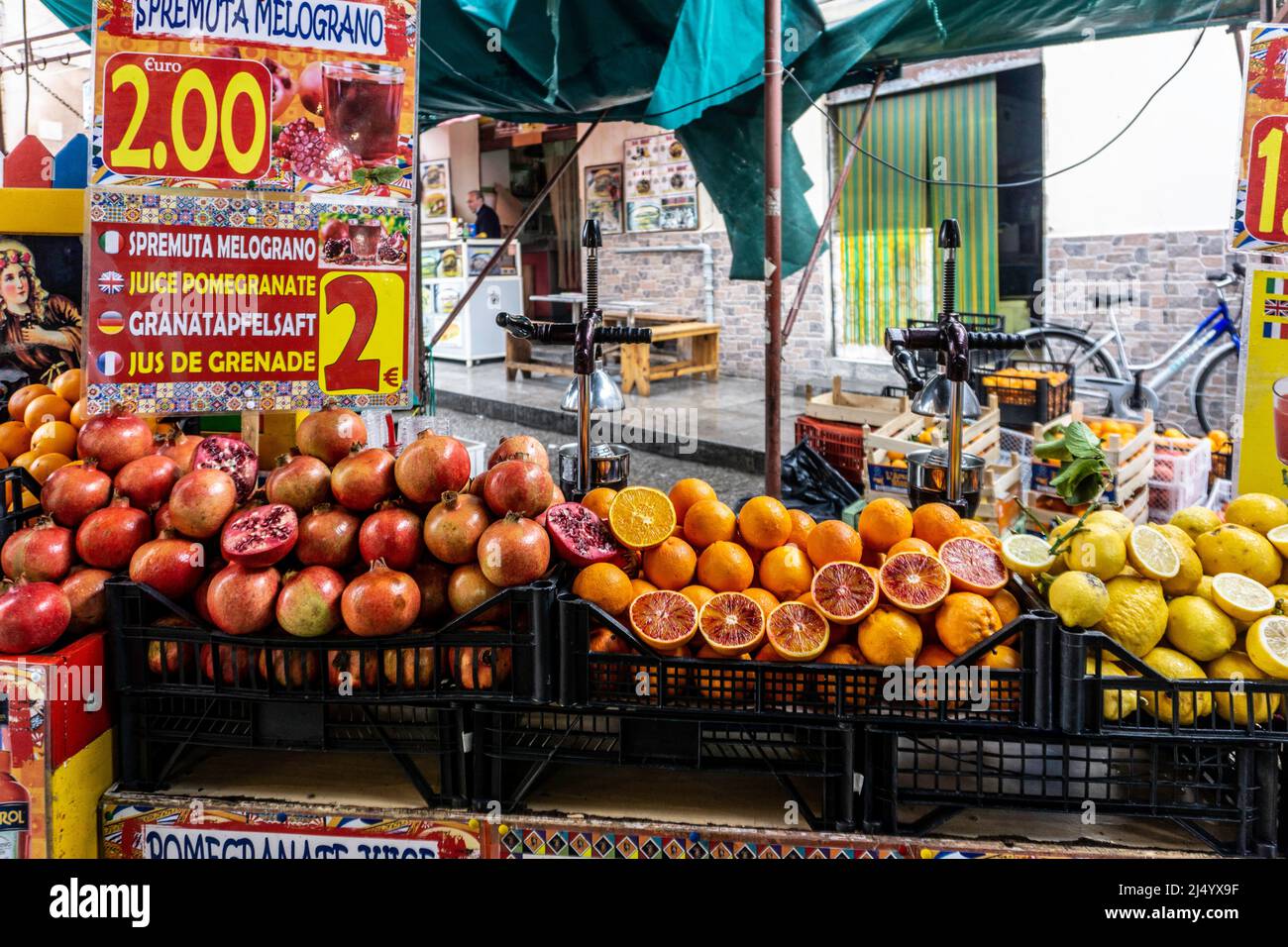 Una bancarella di succhi nel mercato all'aperto di Ballaró, Palermo, Sicilia, Italia che vende una varietà di succhi di frutta appena sfornati. Foto Stock