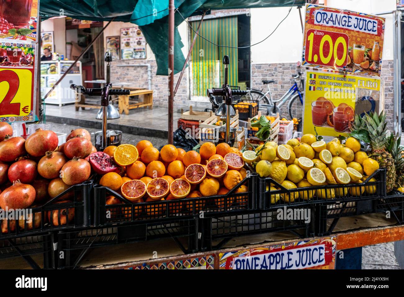 Una bancarella di succhi nel mercato all'aperto di Ballaró, Palermo, Sicilia, Italia che vende una varietà di succhi di frutta appena sfornati. Foto Stock