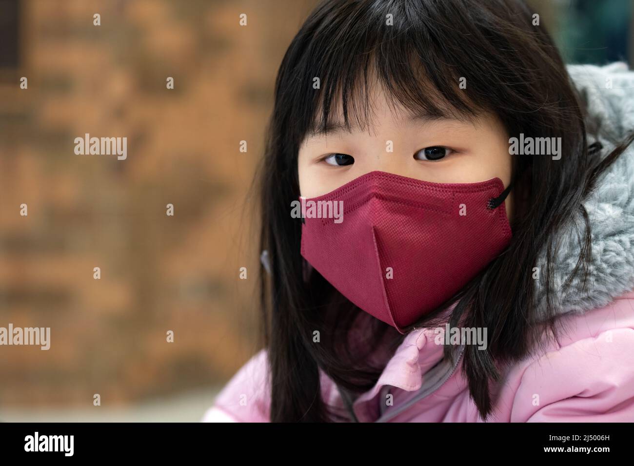 Piccola ragazza asiatica capretto che indossa maschera facciale Foto Stock