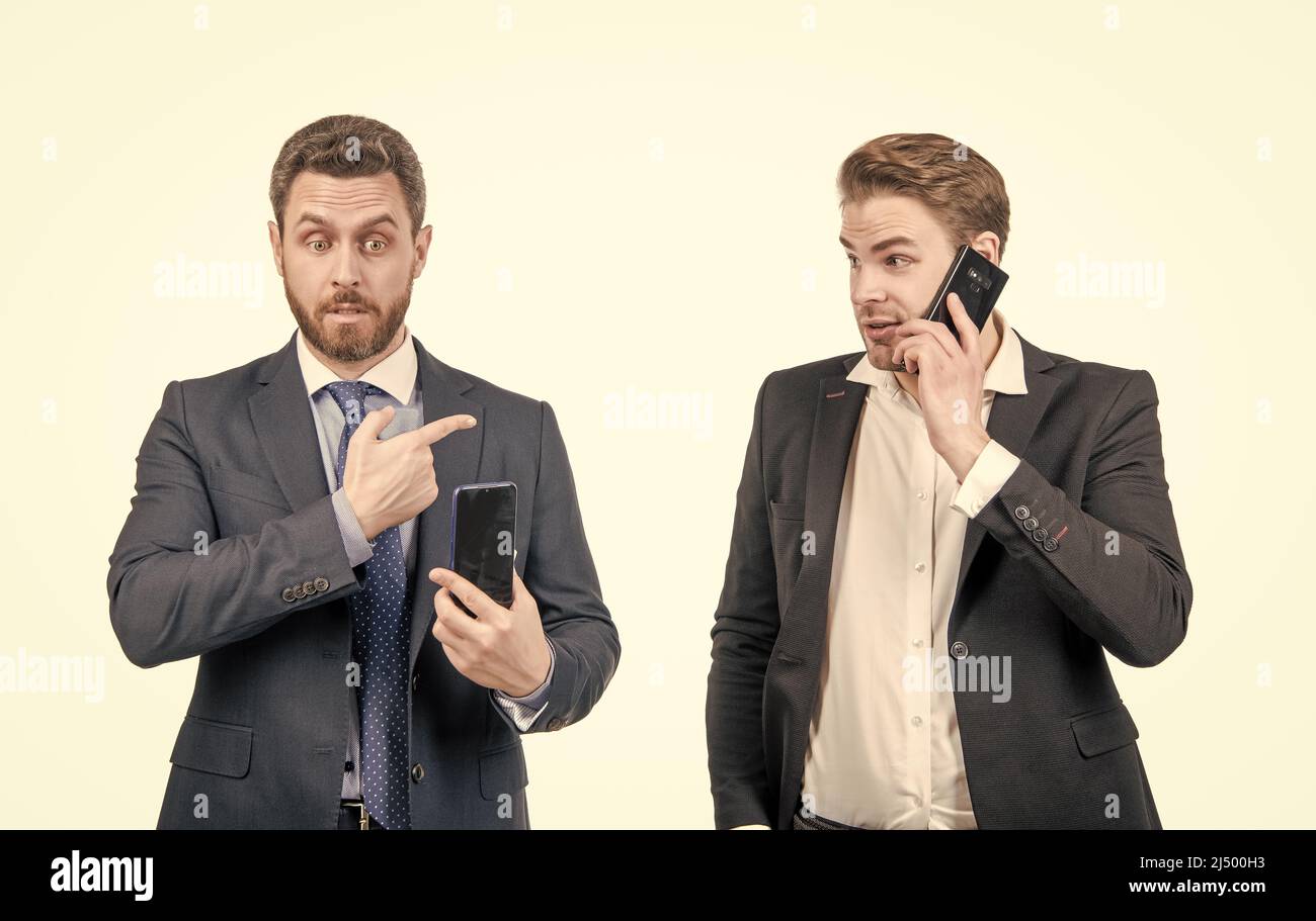 stupito businesspeople di tipo che punta dito su uomo che parla al telefono, il commercio in linea. Foto Stock