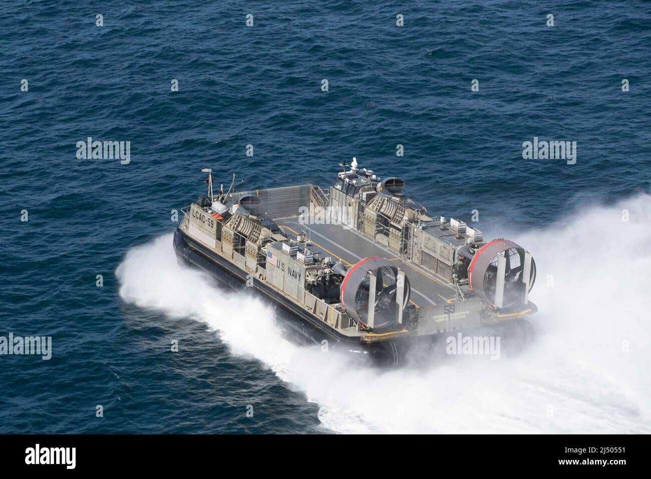 220415-N-IL330-1260 OCEANO PACIFICO (APRILE 15, 2022) – un'imbarcazione di atterraggio, Air cuscino (LCAC) opera nelle vicinanze della nave d'assalto anfibio USS Tripoli (LHA 7) nell'Oceano Pacifico, 15 aprile 2022. Tripoli sta conducendo operazioni di routine nella flotta USA 3rd. (STATI UNITI Foto Navy di Seaman Austyn Riley, specialista della comunicazione di massa) Foto Stock