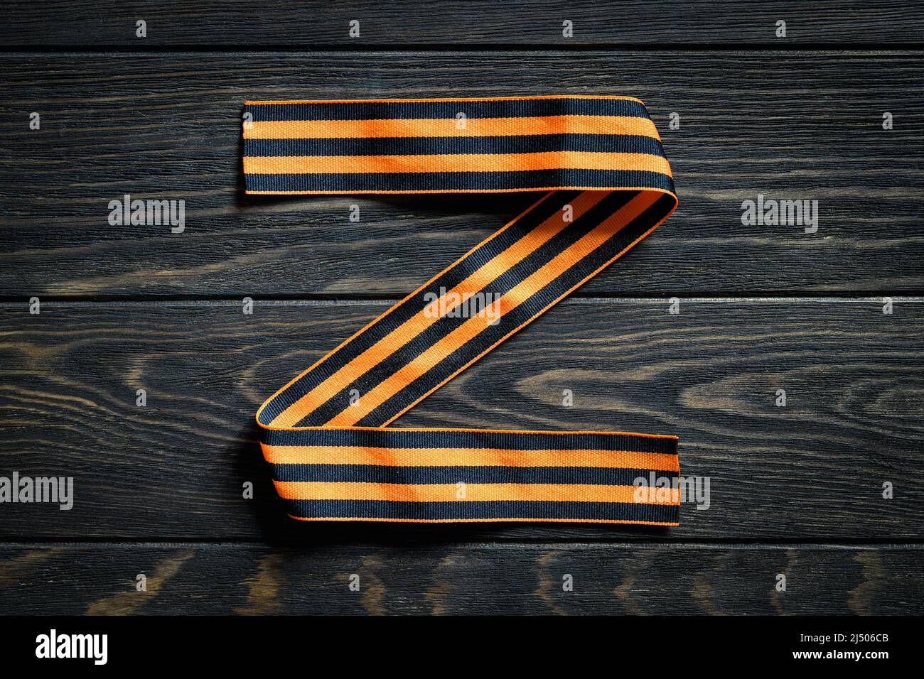 Lettera Z realizzata con nastro a strisce George su sfondo di legno scuro, logo Z per la forza militare russa, simbolo militare e segno della Russia utilizzato in Russia-U. Foto Stock