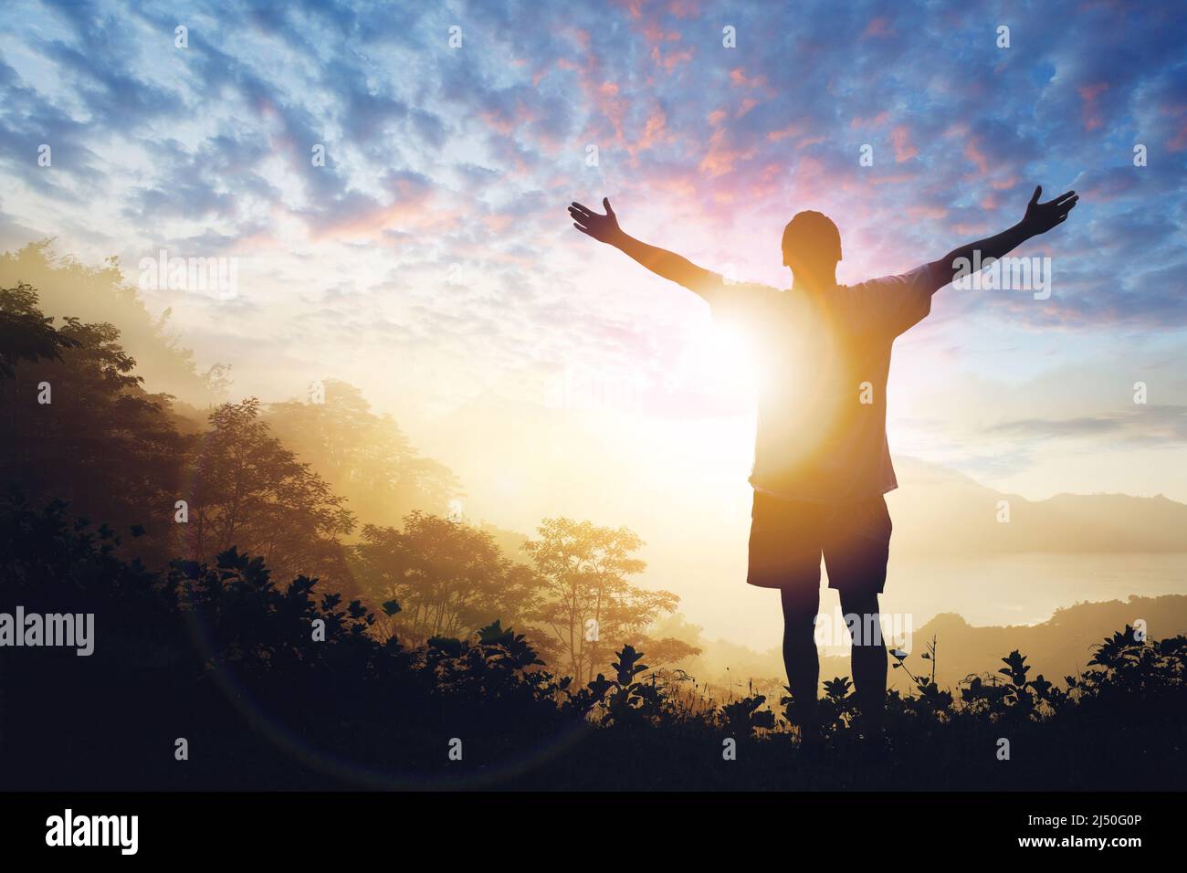 Copia spazio di uomo sollevare mano su cielo tramonto Foto Stock