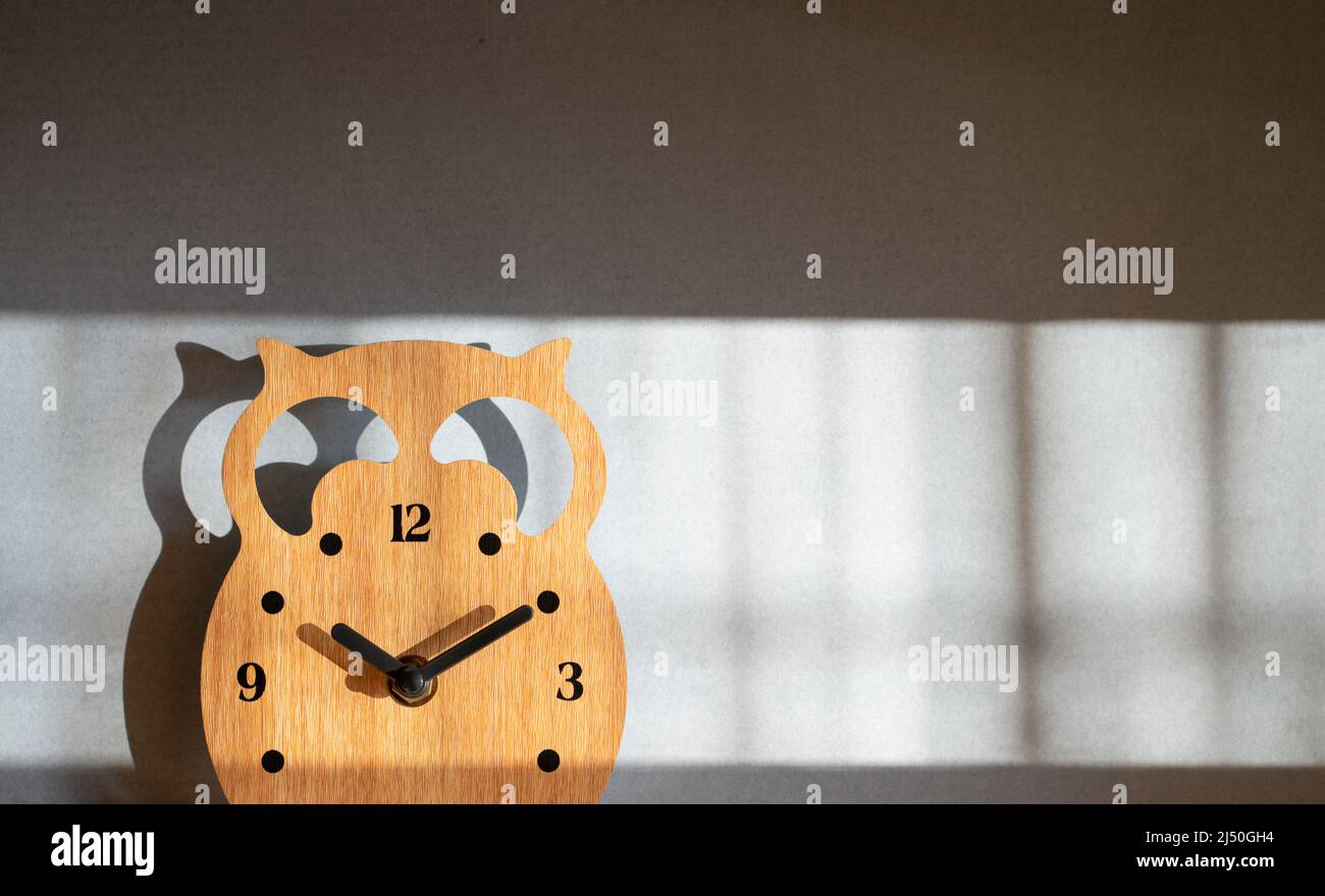 Orologio in legno con ombra, spazio di copia. Concetto di orario e promemoria. Foto Stock