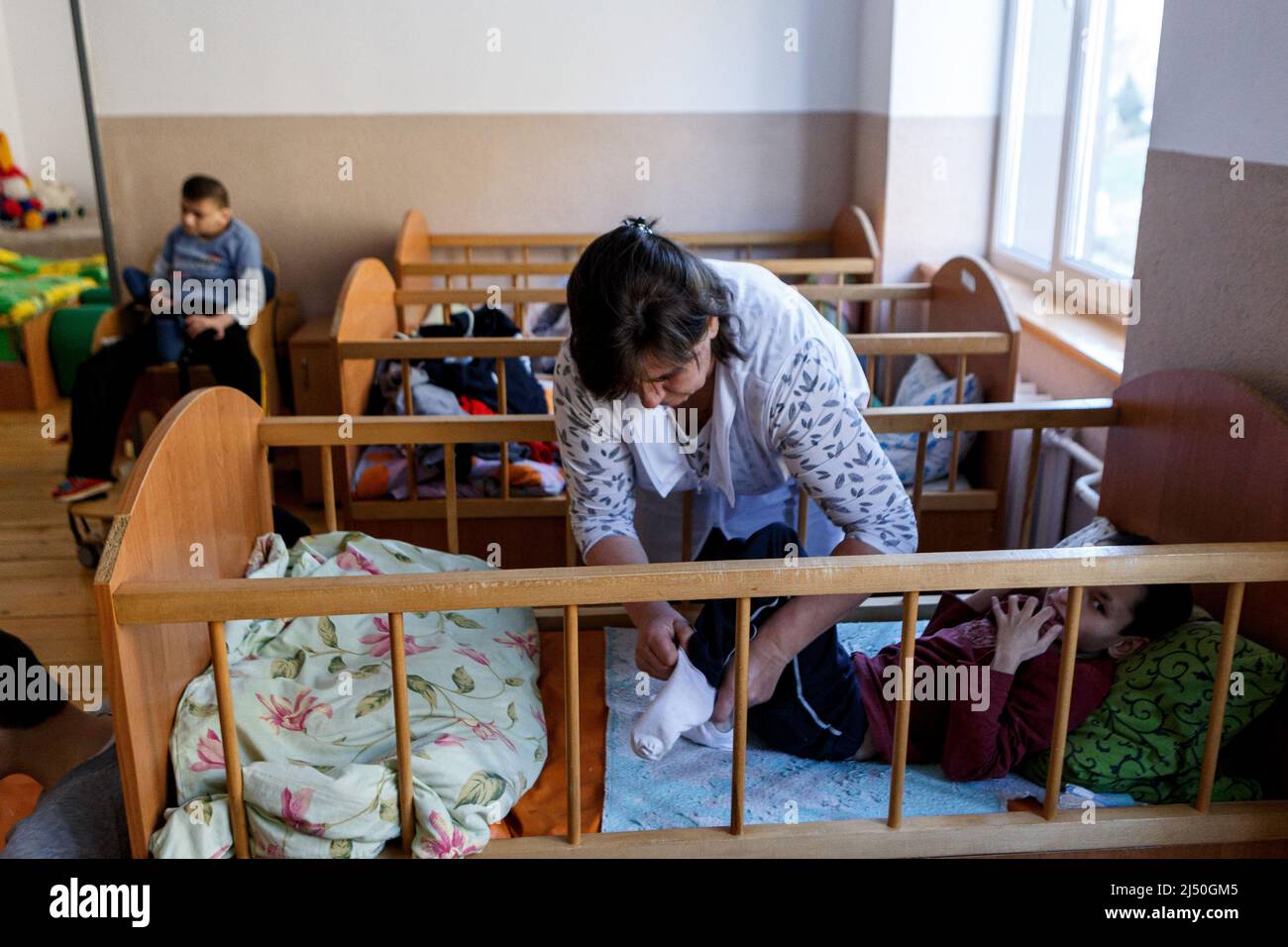 Un dipendente si prende cura delle sue accuse in quanto la casa di imbarco per i bambini disabili e mentalmente disabili accoglie 38 bambini con esigenze speciali che sono stati evacuati dalle strutture nella regione di Zhytomyr e Kryvyi Rih, villaggio di Vilshany, regione di Zakarpattia, Ucraina occidentale, aprile 15, 2022. Foto di Serhii Hudak/Ukrinform/ABACAPRESS.COM Foto Stock
