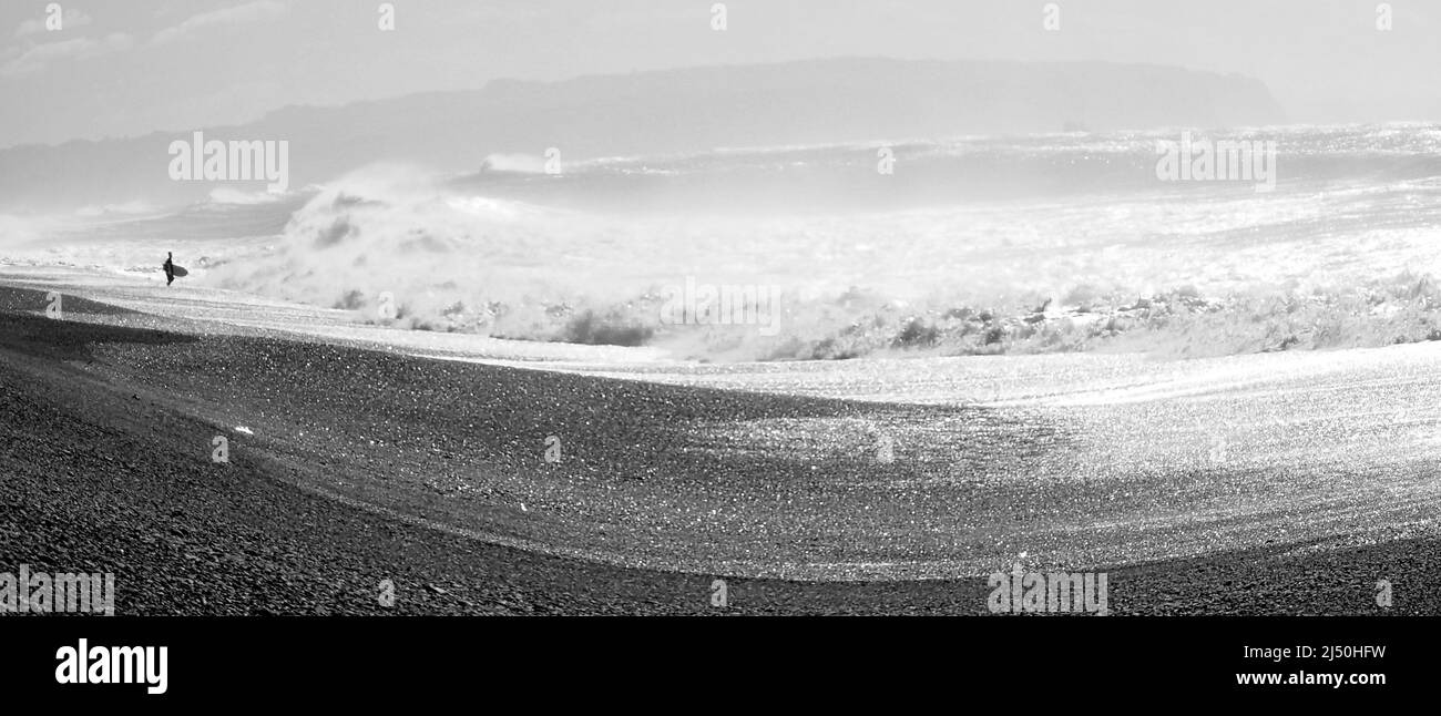 Un surfista solista in attesa del momento giusto per entrare, con onde selvagge che si infrangono sulla Napier's Marine Parade Foto Stock