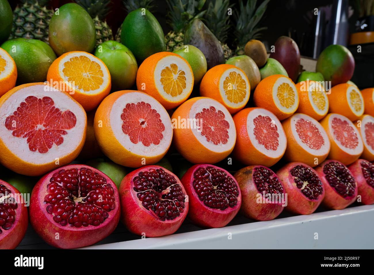 verde, arancione e rosso sfondo di frutta fresca in una fila. motivo colore. vitamina naturale Foto Stock