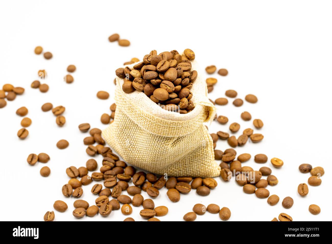Chicchi di caffè isolati su sfondo bianco. Pieno di chicchi di caffè in un sacco. Primo piano. Foto Stock