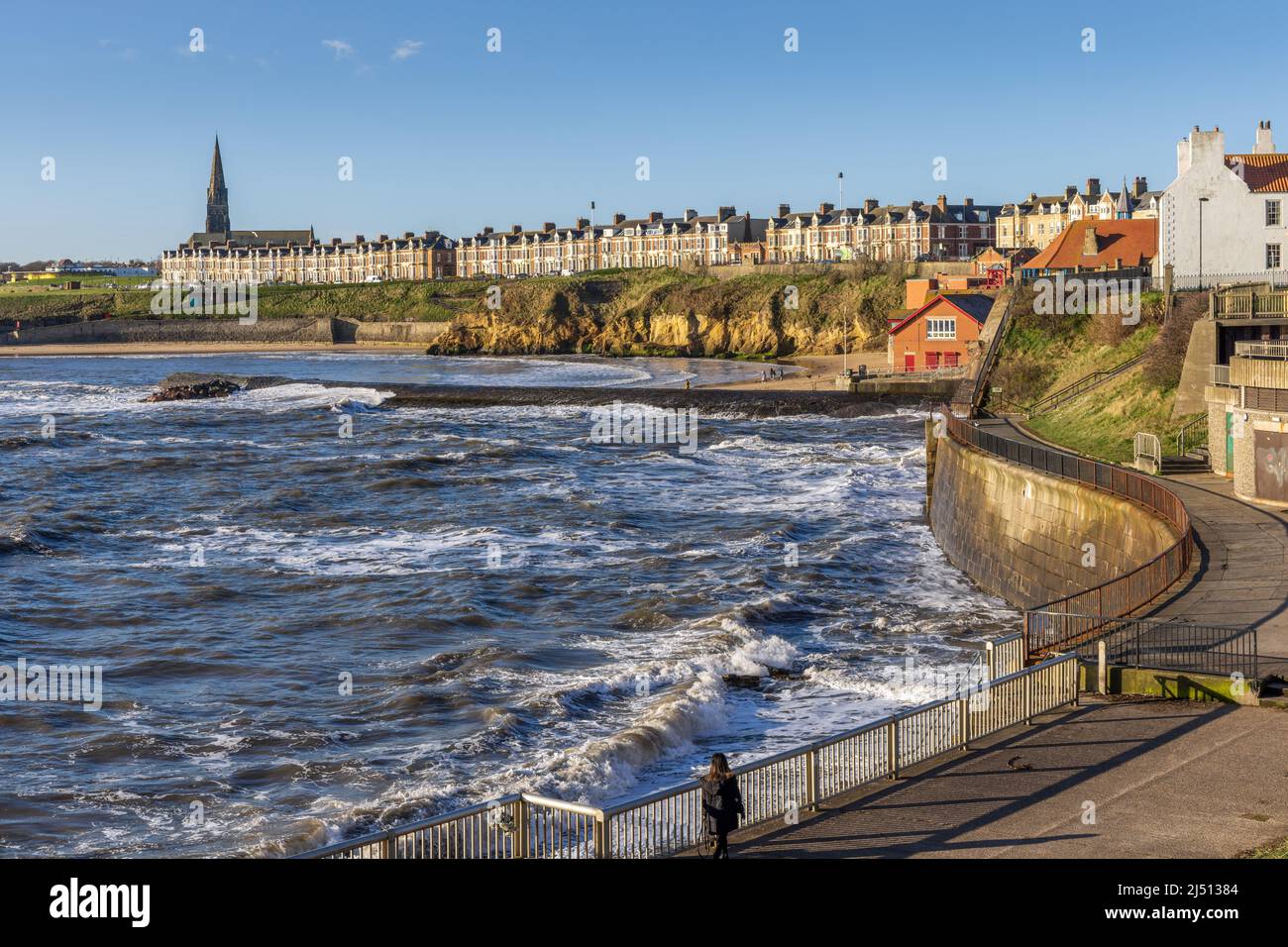 Onde forti ad alta marea che colpiscono le pareti del porto di Cullercoats a North Tyneside la mattina presto della primavera. Foto Stock