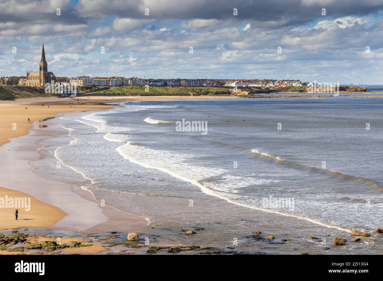 Spiaggia di Long Sands a Tynemouth in una giornata di primavera, con la chiesa di St George a Cullercoats in lontananza, Tyne and Wear, Inghilterra, Regno Unito Foto Stock