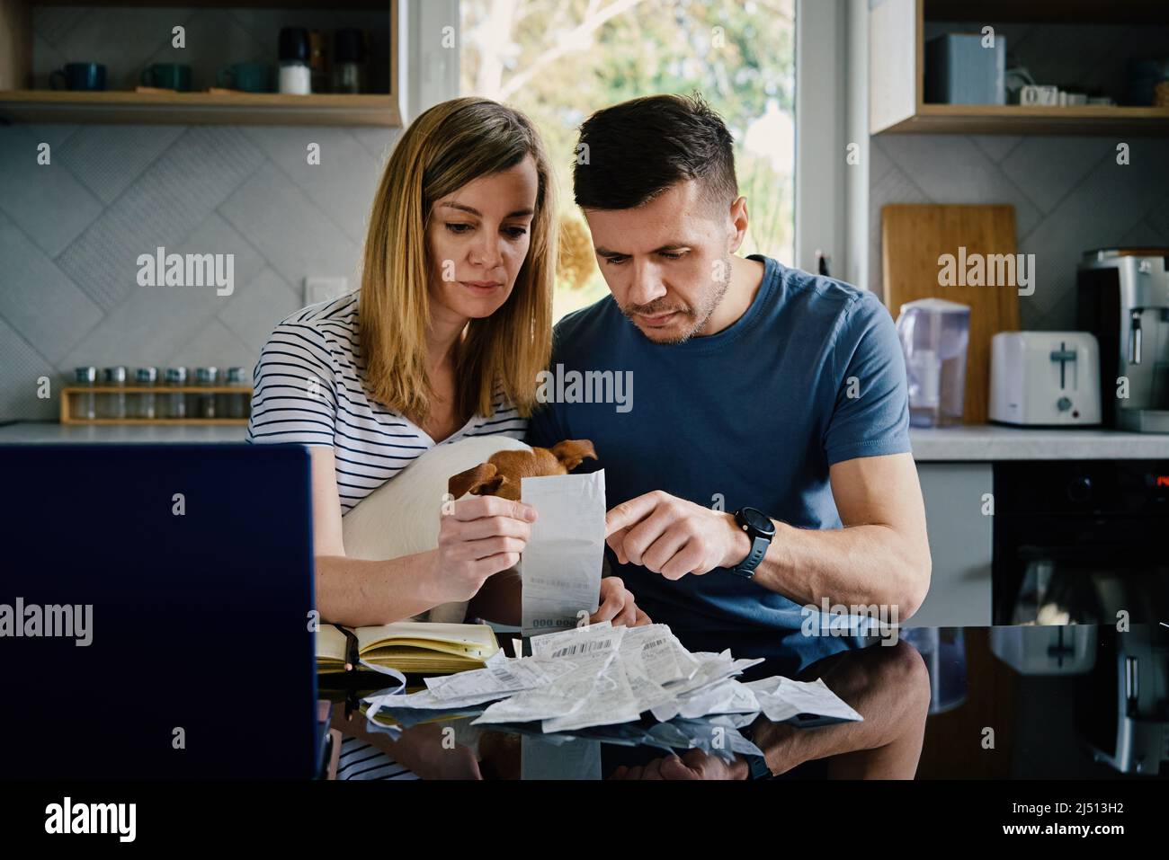 Uomo e donna che controllano le fatture di pagamento in cucina a casa. Pianificazione del budget familiare. Coppia calcolare le bollette e avere stress Foto Stock