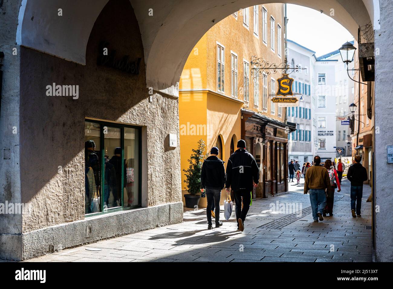 Salisburgo, Austria - 1 novembre 2019: I turisti camminano attraverso il grande cancello sulla storica via dello shopping nella città vecchia, il colorato edificio. La maggior parte di Sho Foto Stock