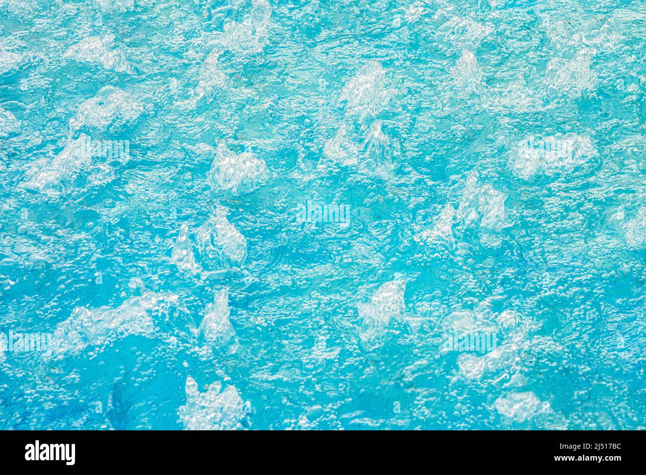 acqua turchese blu in una piscina gorgogliante con idromassaggio, texture sfondo di acqua limpida. Foto Stock