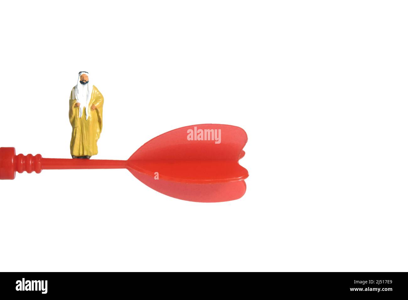 Fotografia di personaggi giocattolo in miniatura. Un sultano che indossa bihst giallo (mantello re) che si trova sopra la freccia rossa volante. Isolato su sfondo bianco. IMA Foto Stock