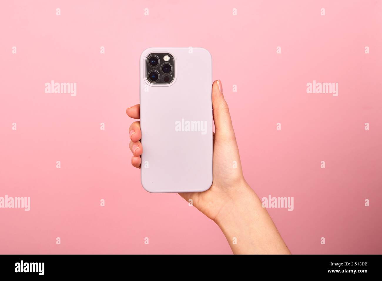 Smartphone bianco femmina con custodia in morbido silicone, vista posteriore . Custodia del telefono mock in su isolato su sfondo blu ombra da una pianta Foto Stock