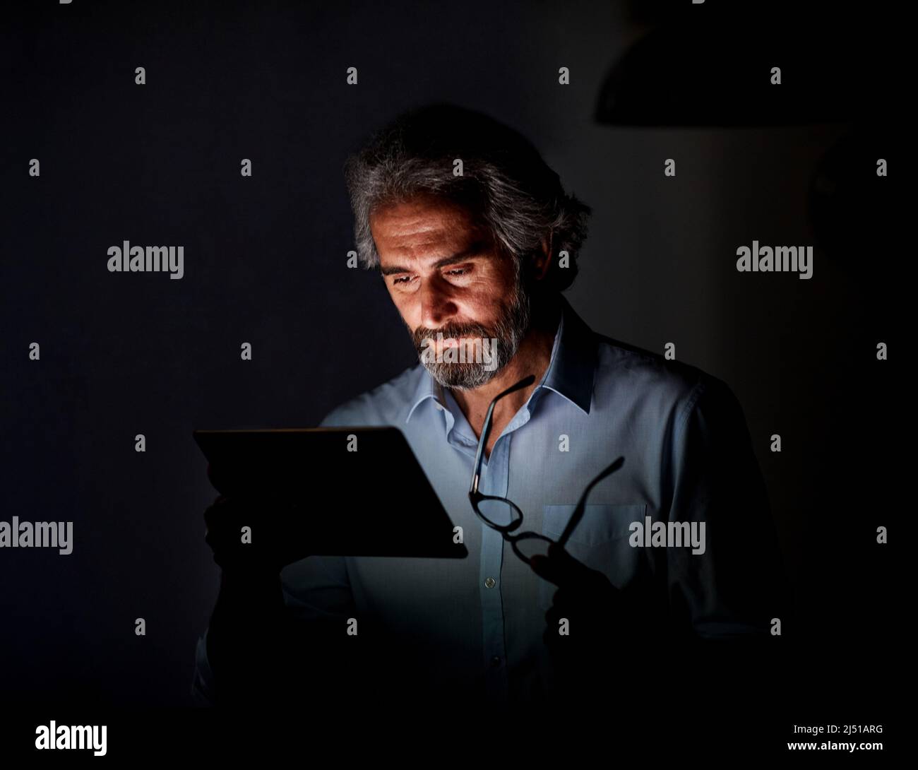 uomo d'affari laptop tablet notte business computer uomo anziano anziano vecchio anziano ufficio tecnologia luce lavoro giovane internet scuro ritardo lavoro Foto Stock