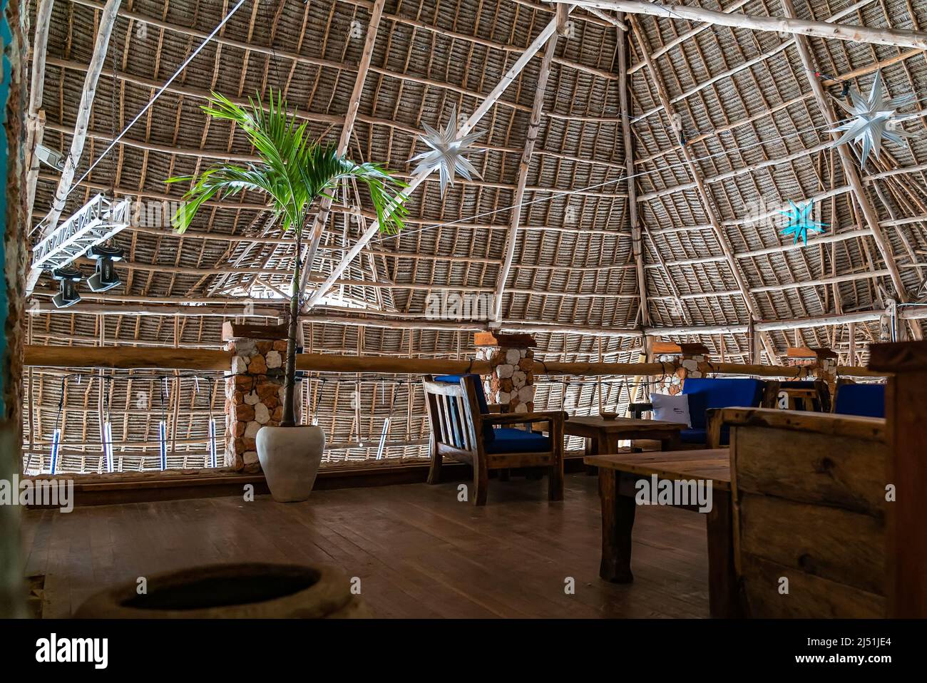 Tavoli di legno nel caffè sotto un tetto. Autentico interno di ristorante a Kendwa, Zanzibar, Tanzania. Foto Stock