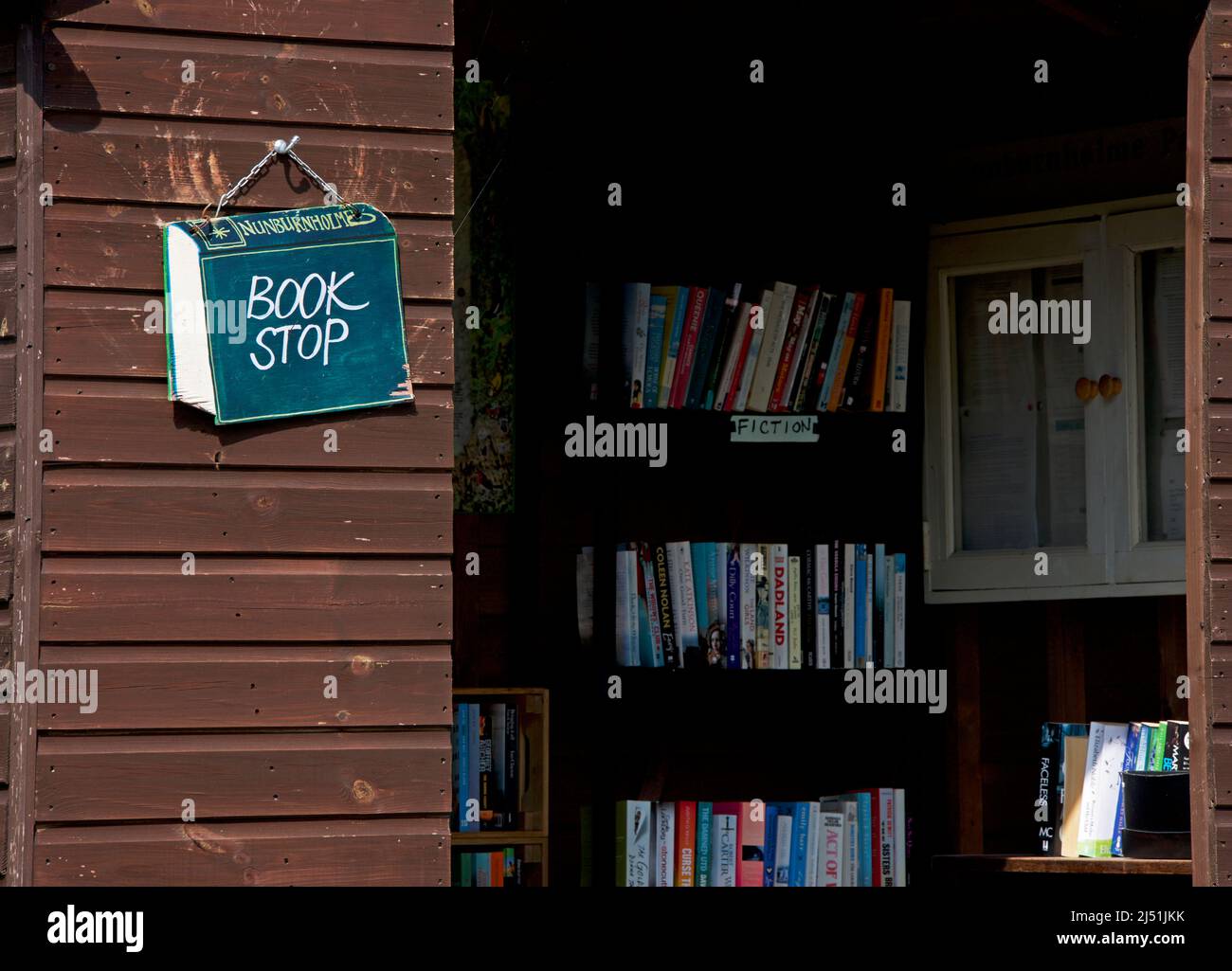 Bus shelter convertito tvo prestito biblioteca nel villaggio di Nunburnholme, Yorkshire orientale, Inghilterra Regno Unito Foto Stock