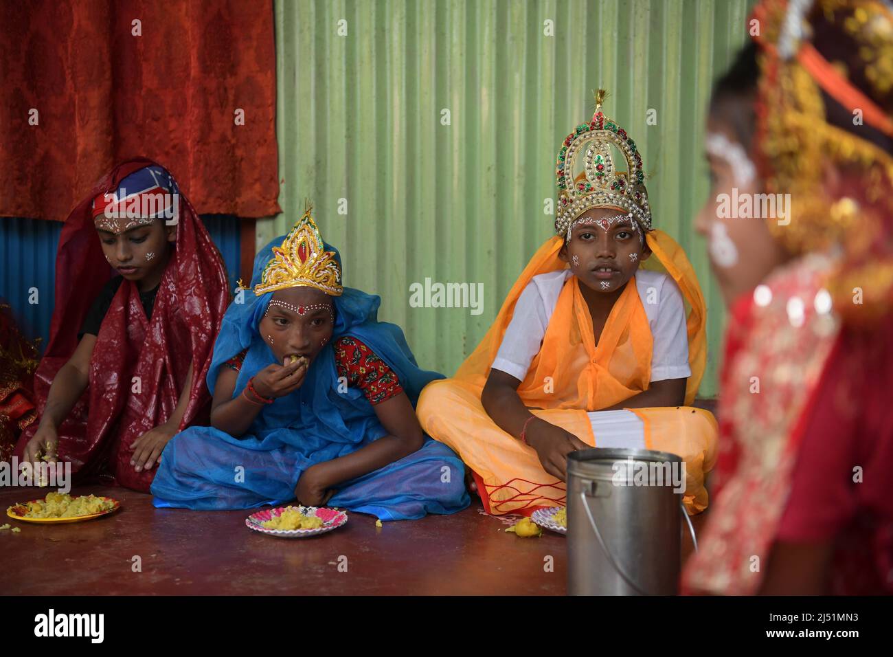 Gli artisti folkloristici pranzano prima di esibirsi ai rituali di Shiver Gajan, un tradizionale festival folkloristico indù pre-raccolto nella periferia di Agartala. Tripura, India. Foto Stock
